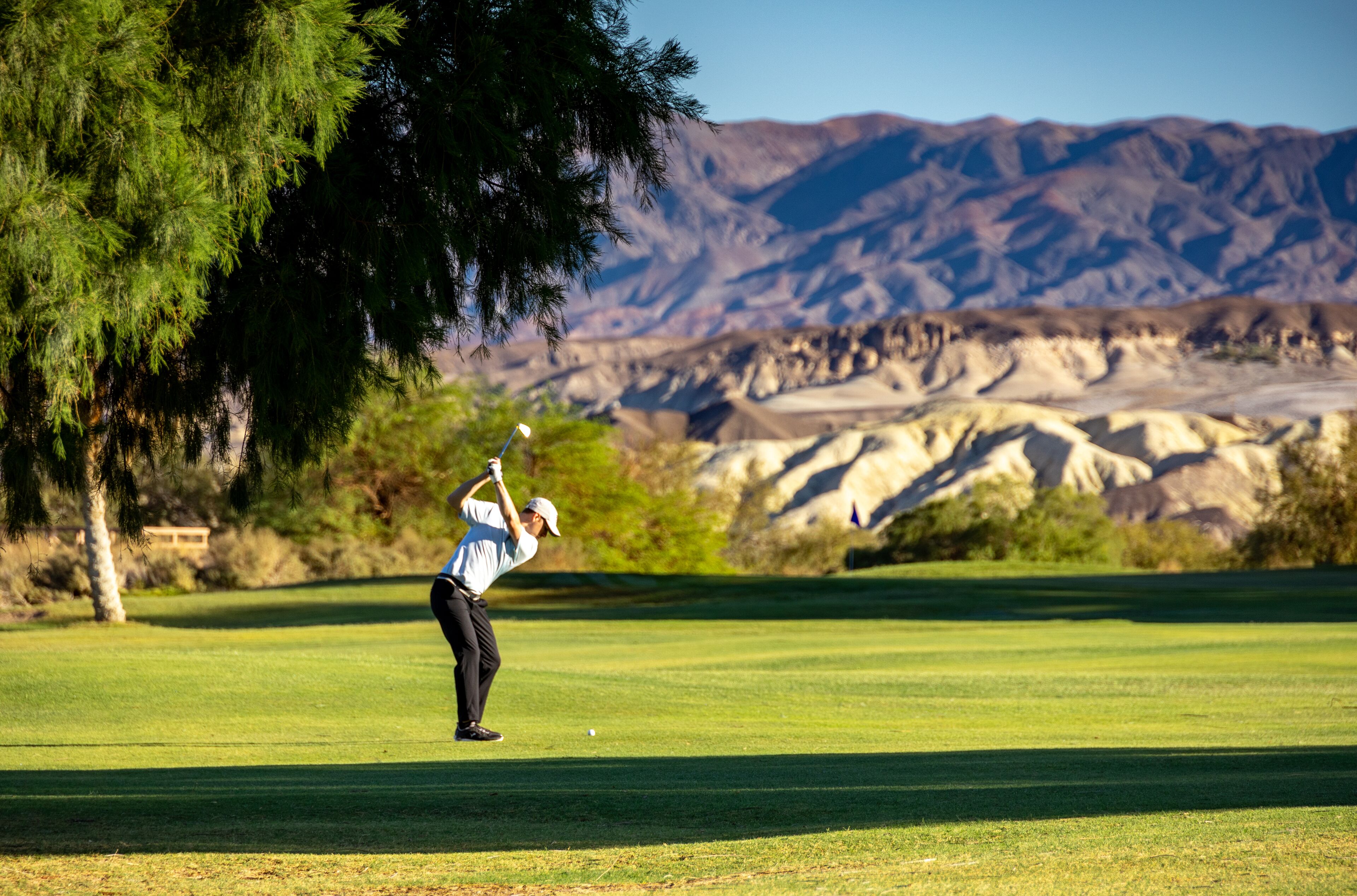 A golf course with a mountainous backdrop.