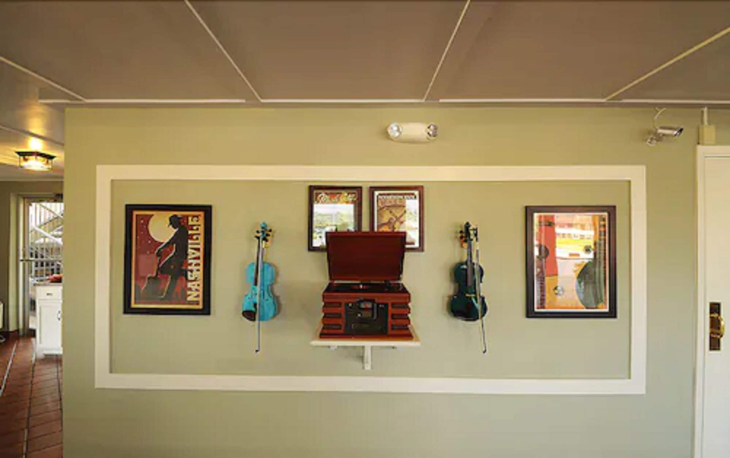 Una parete con opere d'arte incorniciate e strumenti musicali.