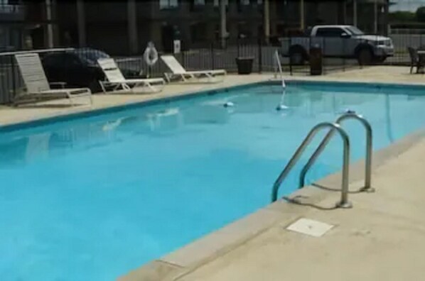 A swimming pool with lounge chairs and a lifebuoy.