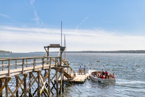 A wooden pier extending into a lake with a boat docked at the end.