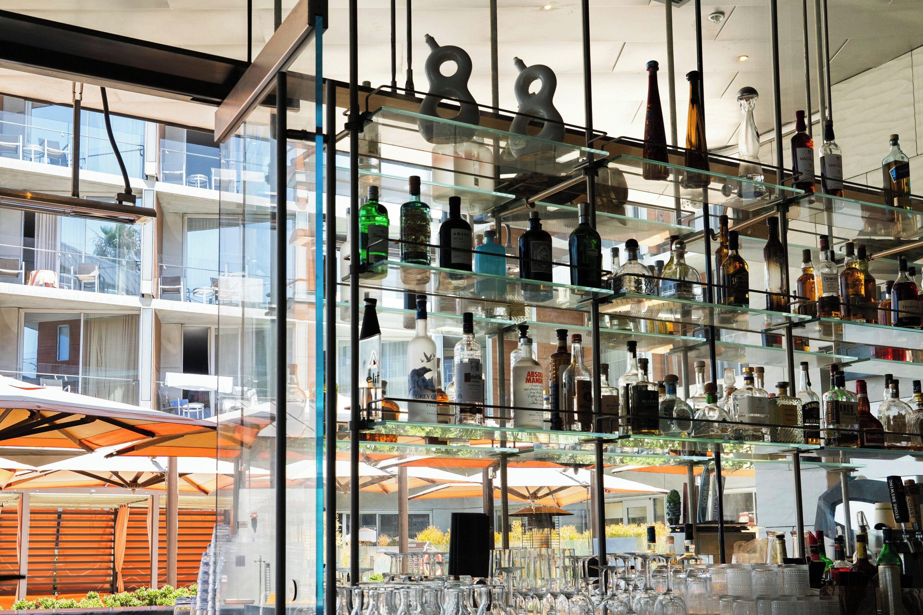 A bar area with multiple shelves of liquor bottles and glasses.