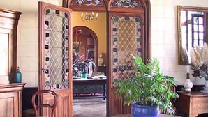 A room with a wooden door, a potted plant, and a mirror on the wall. - Chateau De Jallanges (Vernou-sur-Brenne)