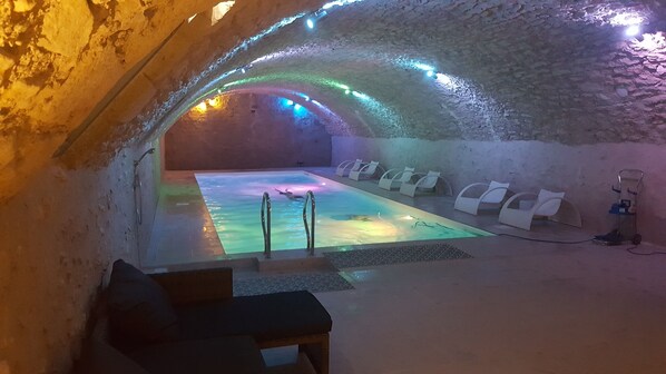 Una piscina techada, una piscina al aire libre de temporada, sombrillas