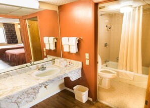A bathroom with a marble sink, a toilet, and a shower area.