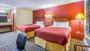 A hotel room with two beds, a chair, a desk, and a lamp. - Rodeway Inn Bonifay (Bonifay)