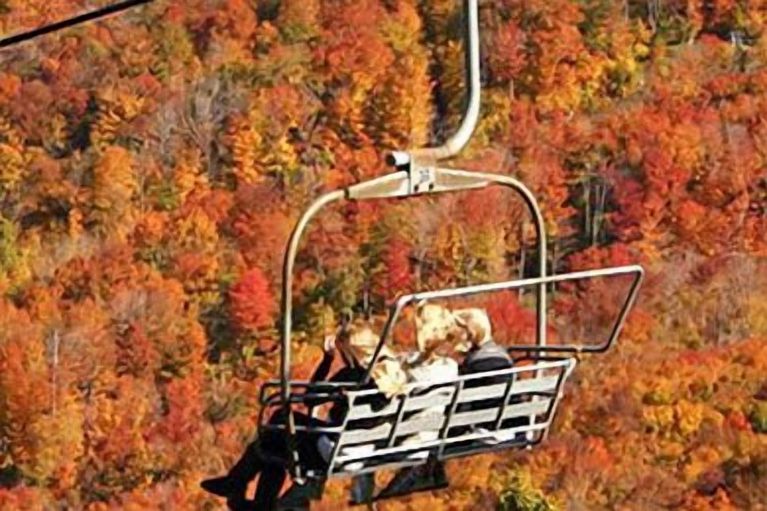 Un telesilla con pasajeros ascendiendo una montaña.