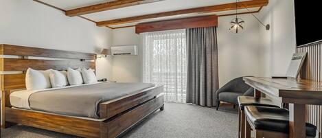 A hotel room with a wooden bed, a desk, and a chair.
