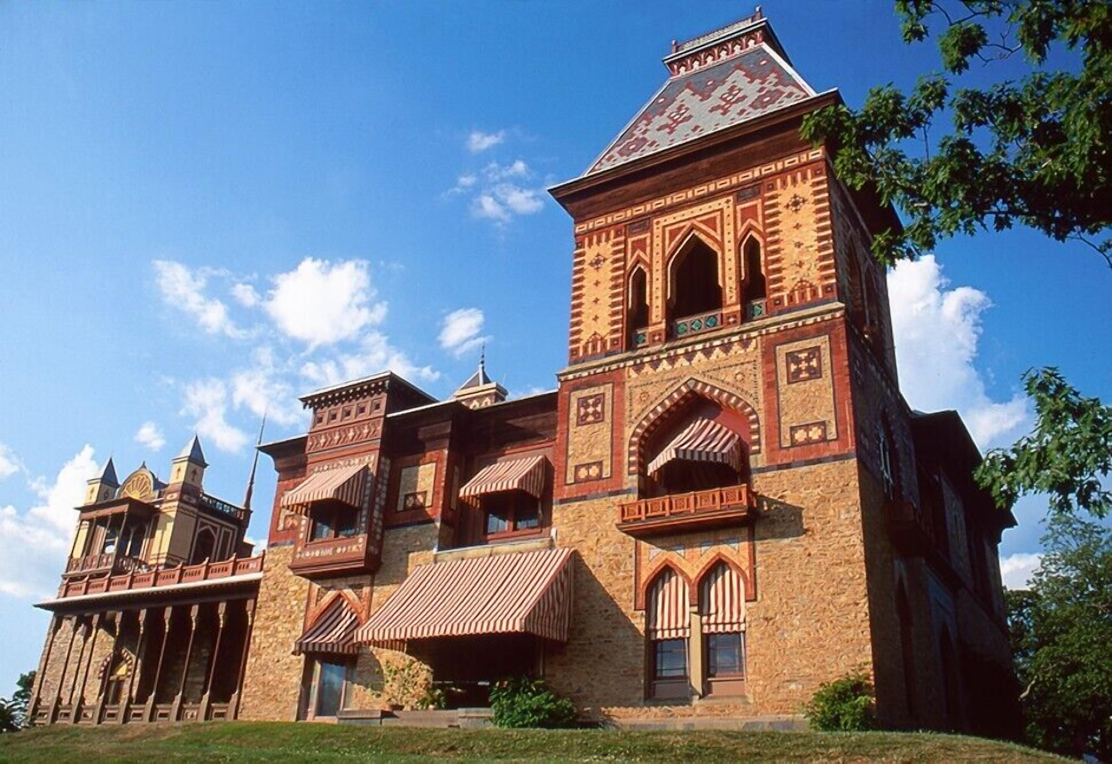 Un grand bâtiment historique doté de nombreuses tours et de fenêtres en arc, qui pourrait être un hôtel ou un bâtiment public.