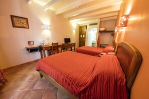 A hotel room with two beds, a desk, a chair, a television, and a bathroom visible through an open door. - Hotel Casa Conzatti (Oaxaca)