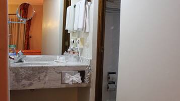 Un baño con lavamanos de mármol, un espejo y un perchero para toallas.
