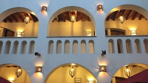 A building facade with multiple arched windows and wall-mounted lighting fixtures.