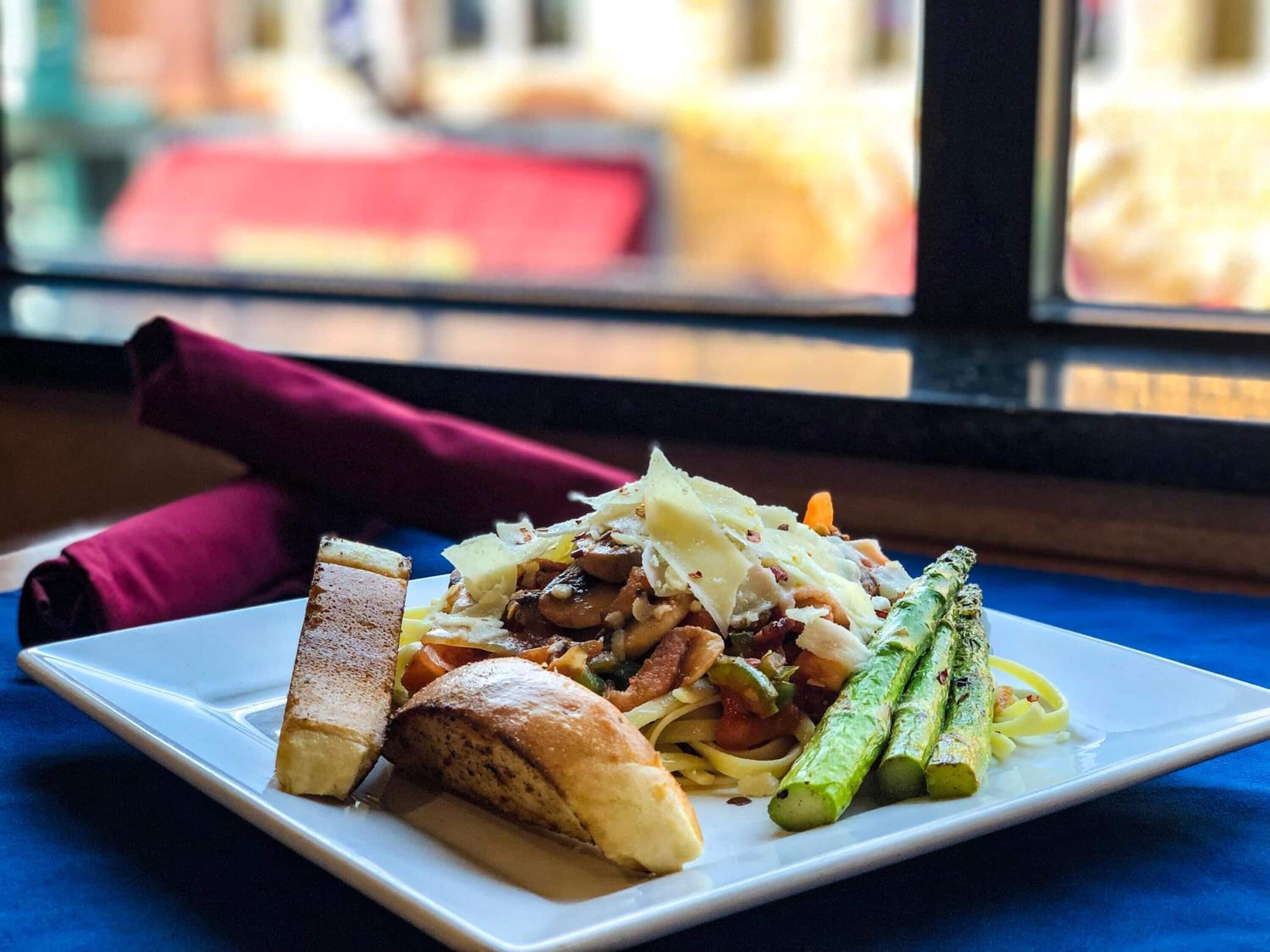 A plate of food with bread, vegetables, and a napkin on a table.