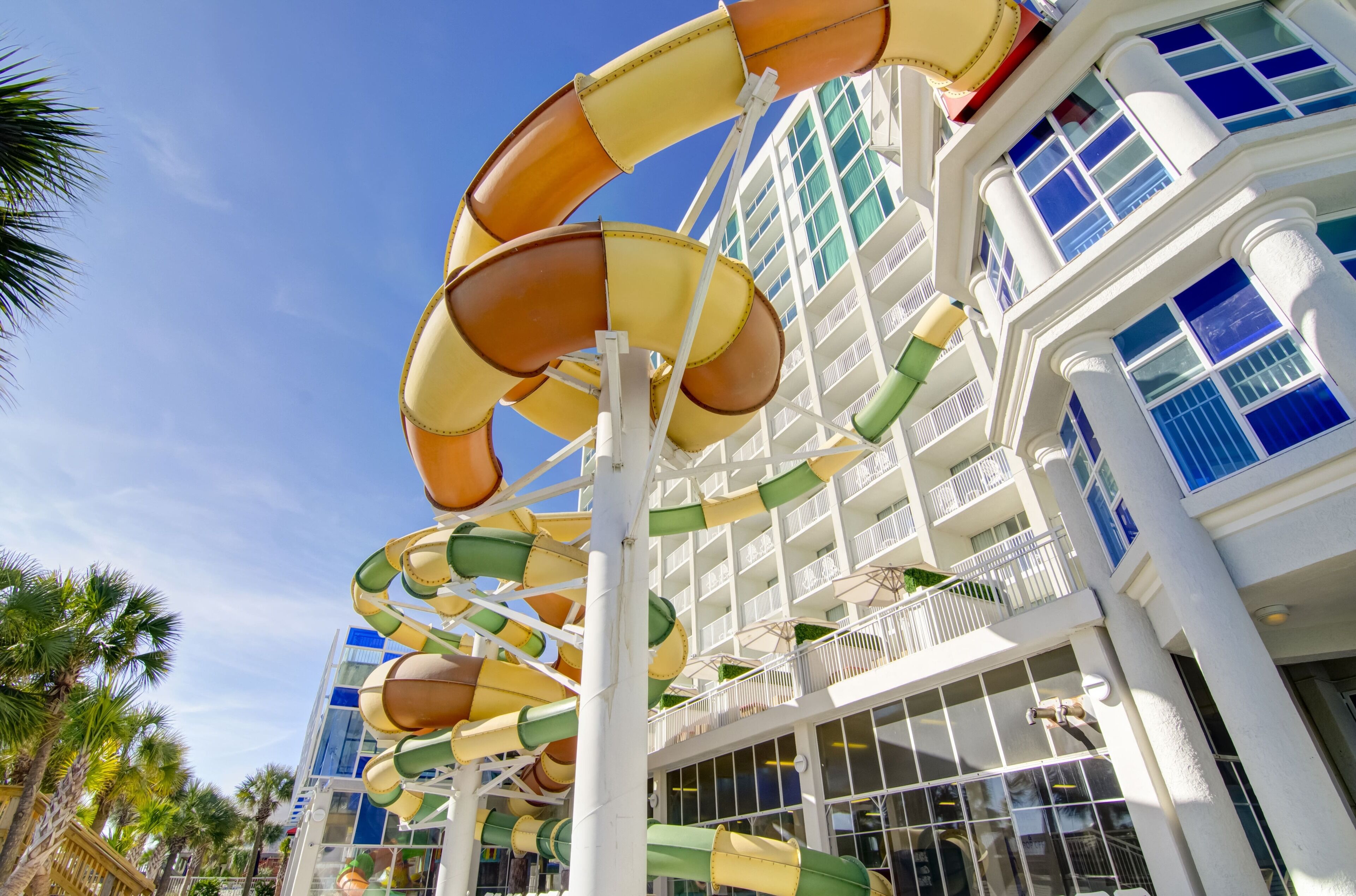 A multi-level water slide structure with a white building in the background.