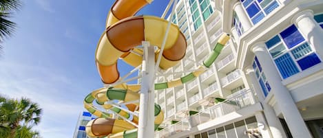 A multi-level water slide structure with a white building in the background.