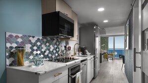 A modern kitchen with a large island, built-in oven, and a view to the outside. - Crown Reef Beach Resort and Waterpark (Myrtle Beach)