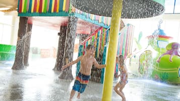 A water play area with colorful structures and a large umbrella.
