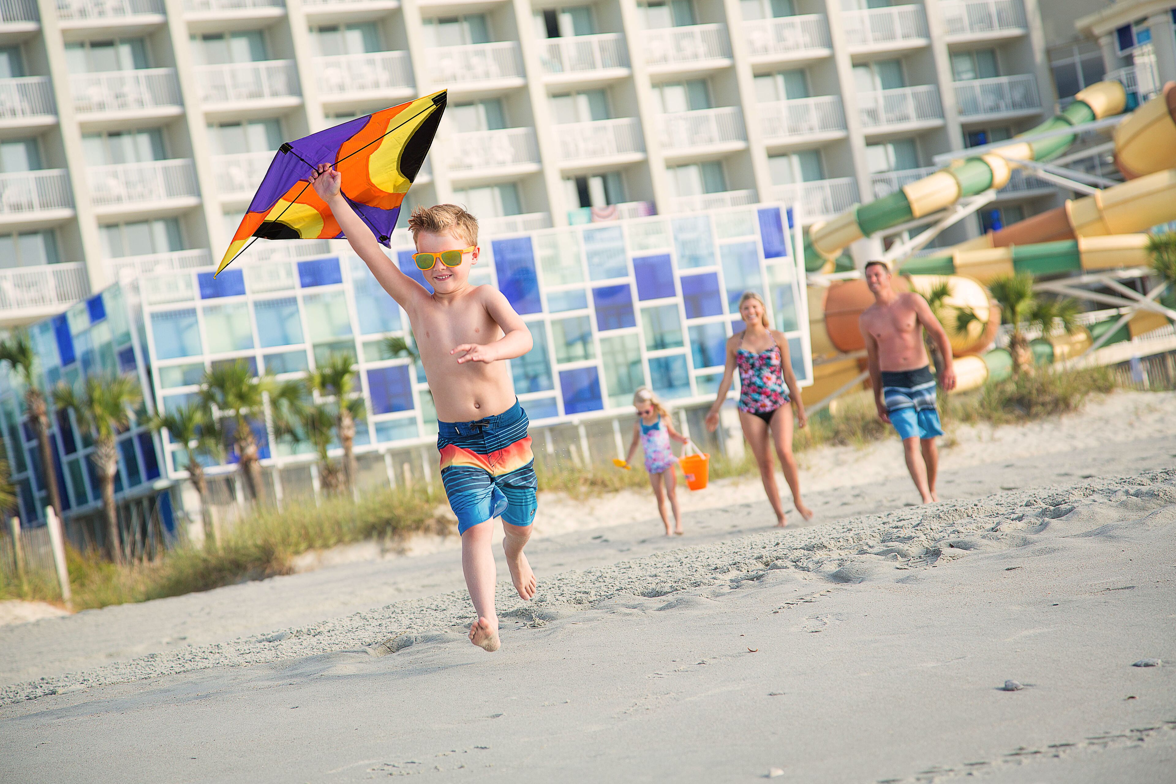 A beach scene with a hotel in the background.
