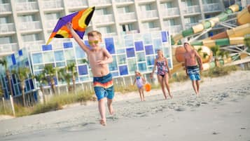 A beach scene with a hotel in the background.