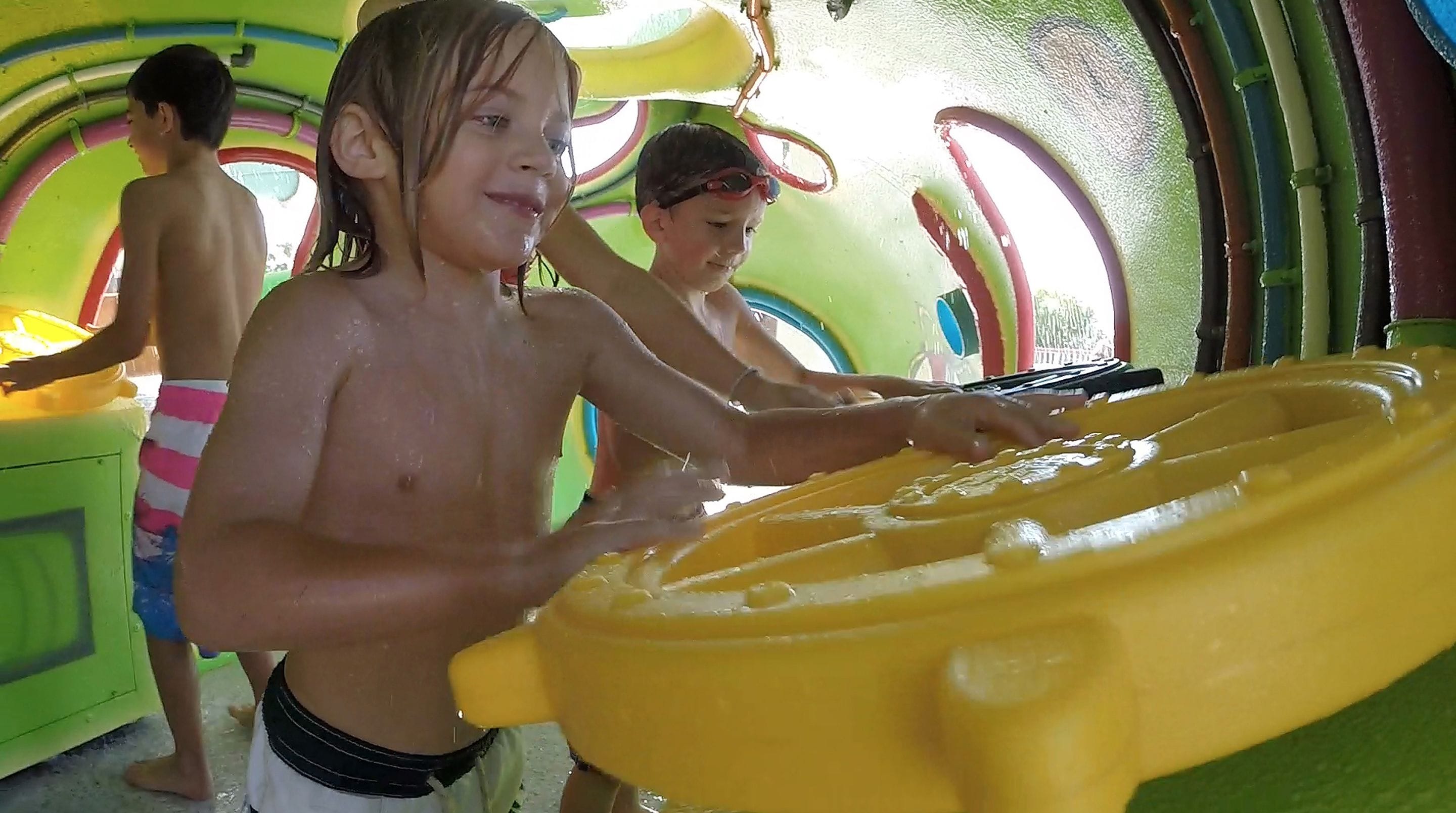 A child playing with a yellow toy in a colorful indoor play area.