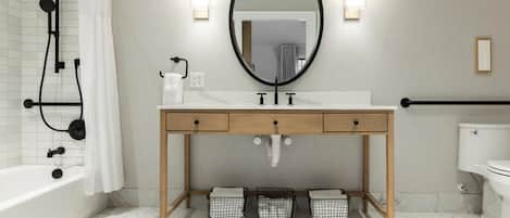 A bathroom with a bathtub, toilet, sink with a mirror, and a shower.