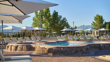 Relax by the serene pool surrounded by lush greenery and distant mountains.