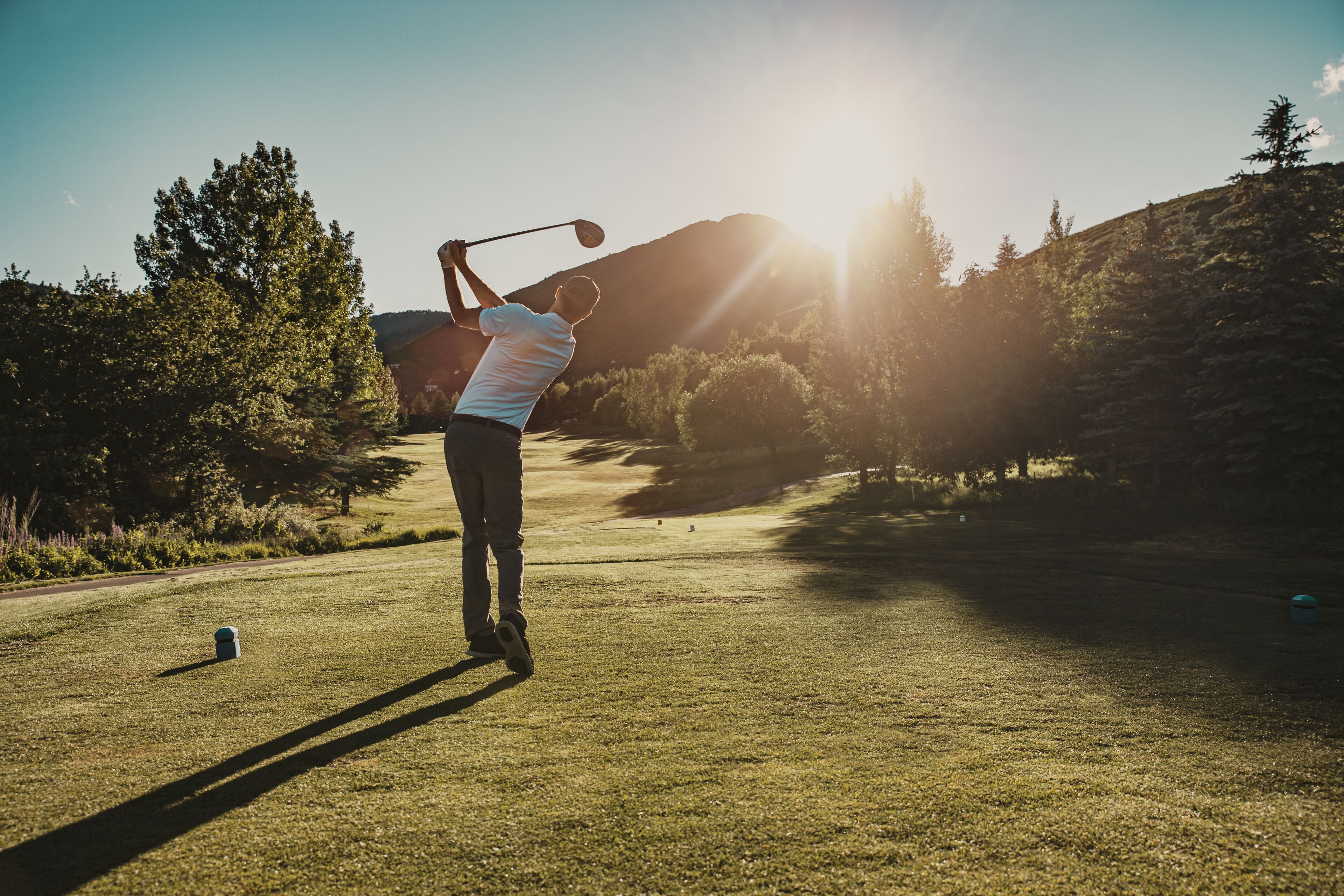 A person playing golf on a sunny day.