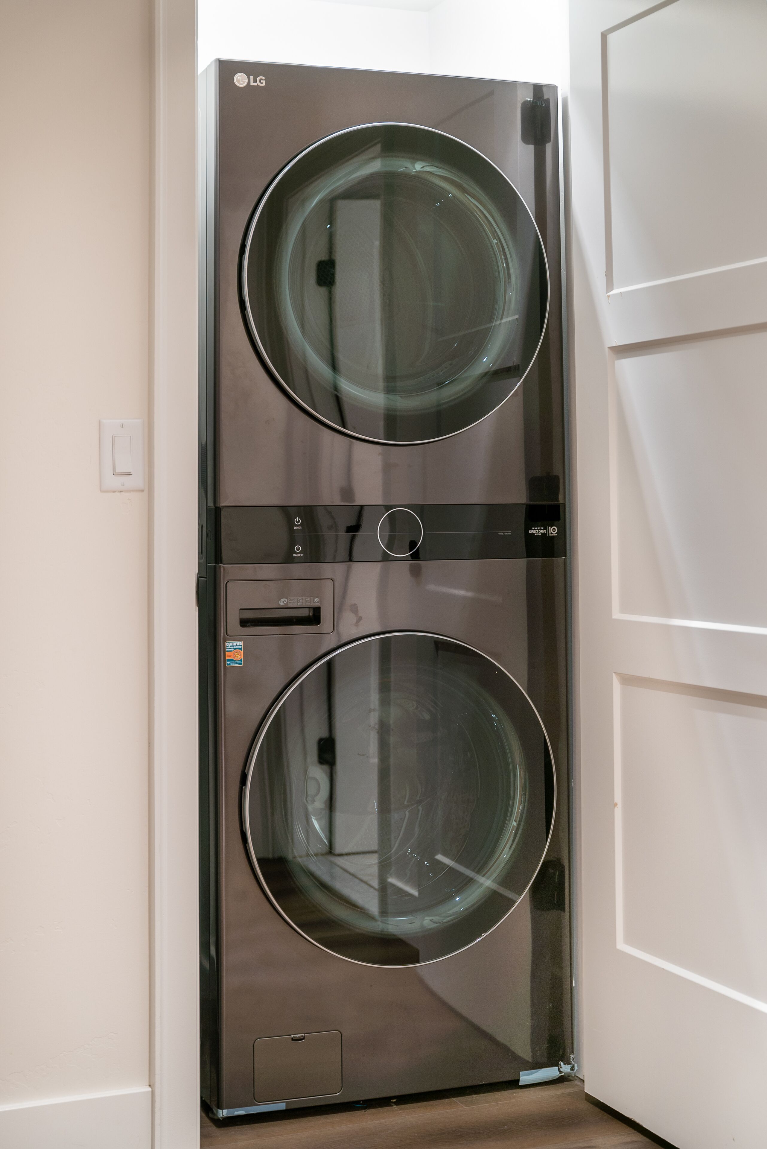A stainless steel LG front-loading washer and dryer unit with a control panel and a digital display.