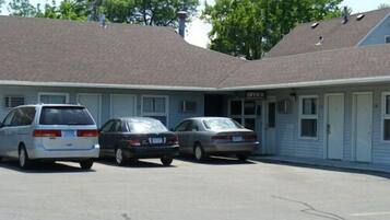 A motel with three parked cars in front.