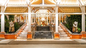 A grand entrance with a staircase, white pillars, and a chandelier. - Bali Garden Beach Resort (Kuta)