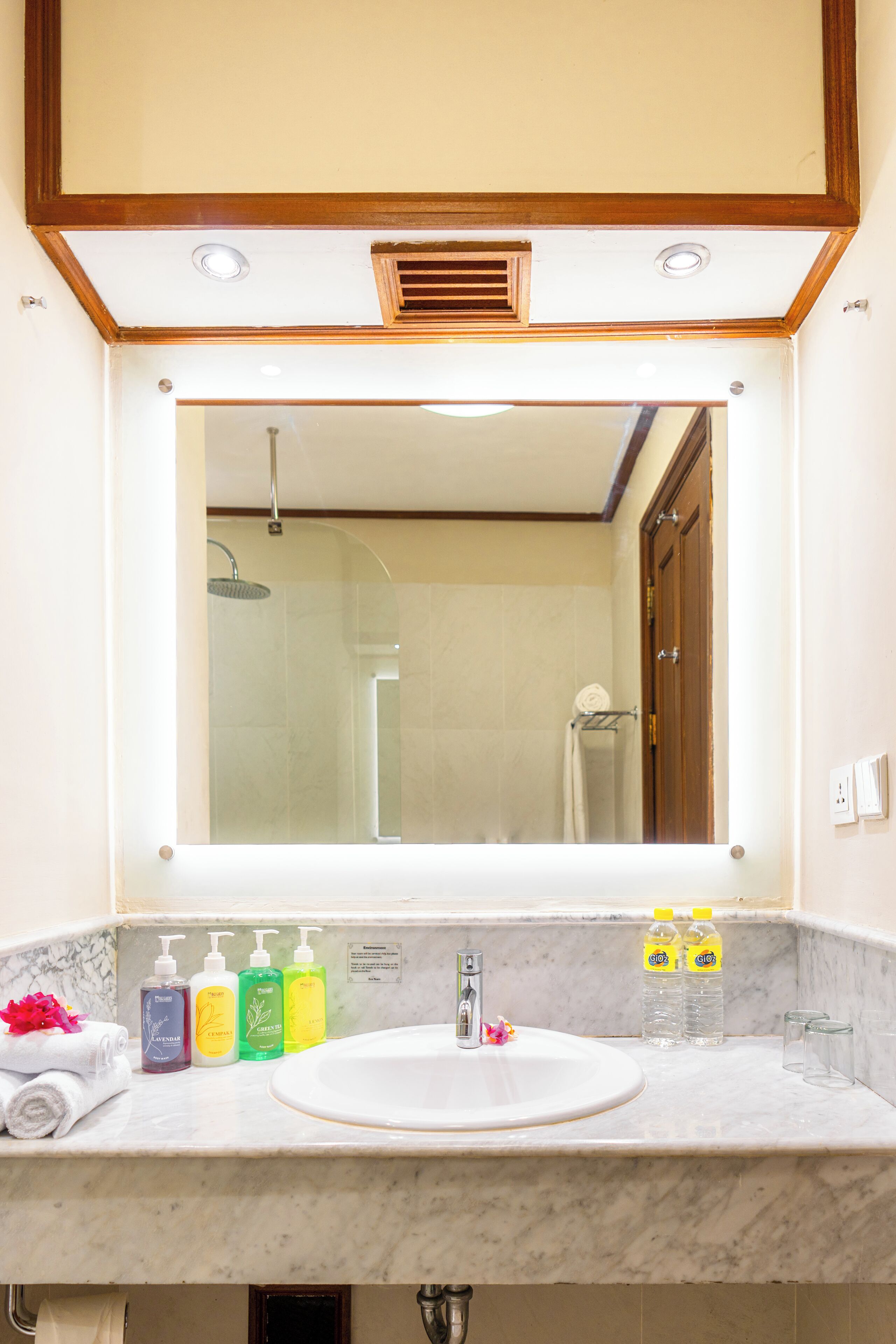 Een badkamer met een grote spiegel, een wastafel en een douche.