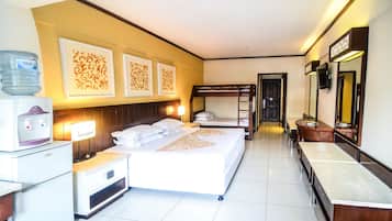 A hotel room with a bed, bedside tables, a water dispenser, a refrigerator, a mirror, and decorative wall art.