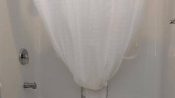 Un baño con bañera, inodoro y cortina de ducha.