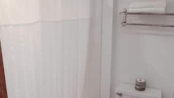 Ein Badezimmer mit Badewanne, Toilette und Handtuchhalter.