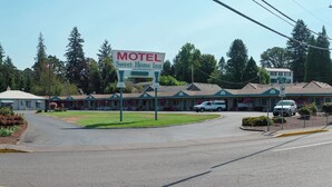 A motel with a large sign, multiple buildings, and a parking lot. - Sweet Home Inn (Sweet Home)