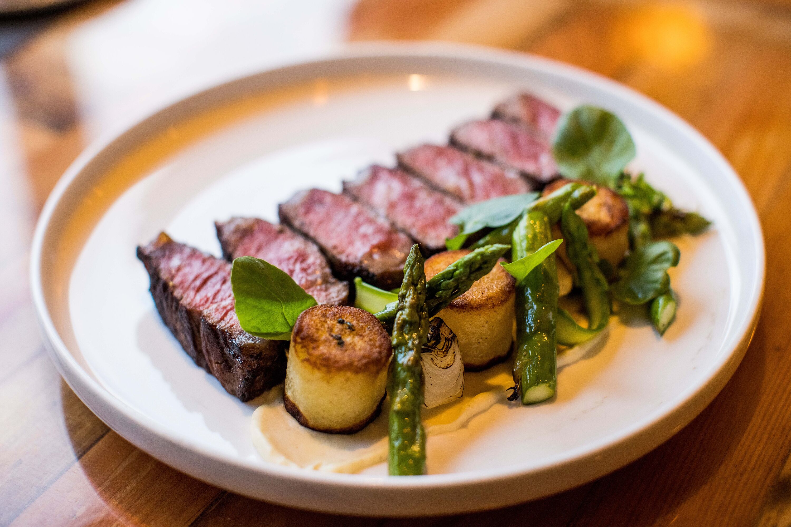 A plate of food with steak, asparagus, and mushrooms.