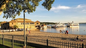A beach with a building labeled "The Riviera" and a dock with boats.