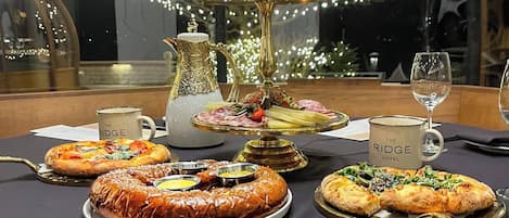 A dining table with various dishes, a pitcher, and a glass of water.