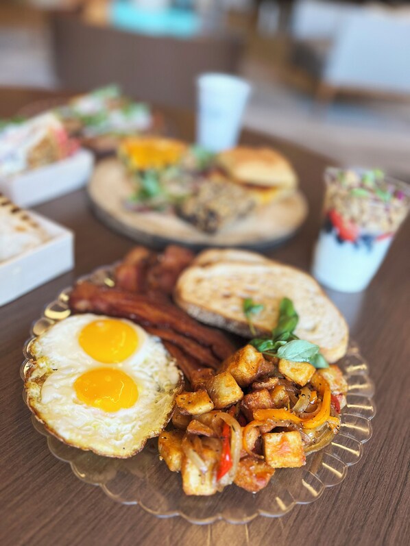 A breakfast plate with eggs, bacon, and sautéed vegetables. - Lodge Geneva National (Lake Geneva)