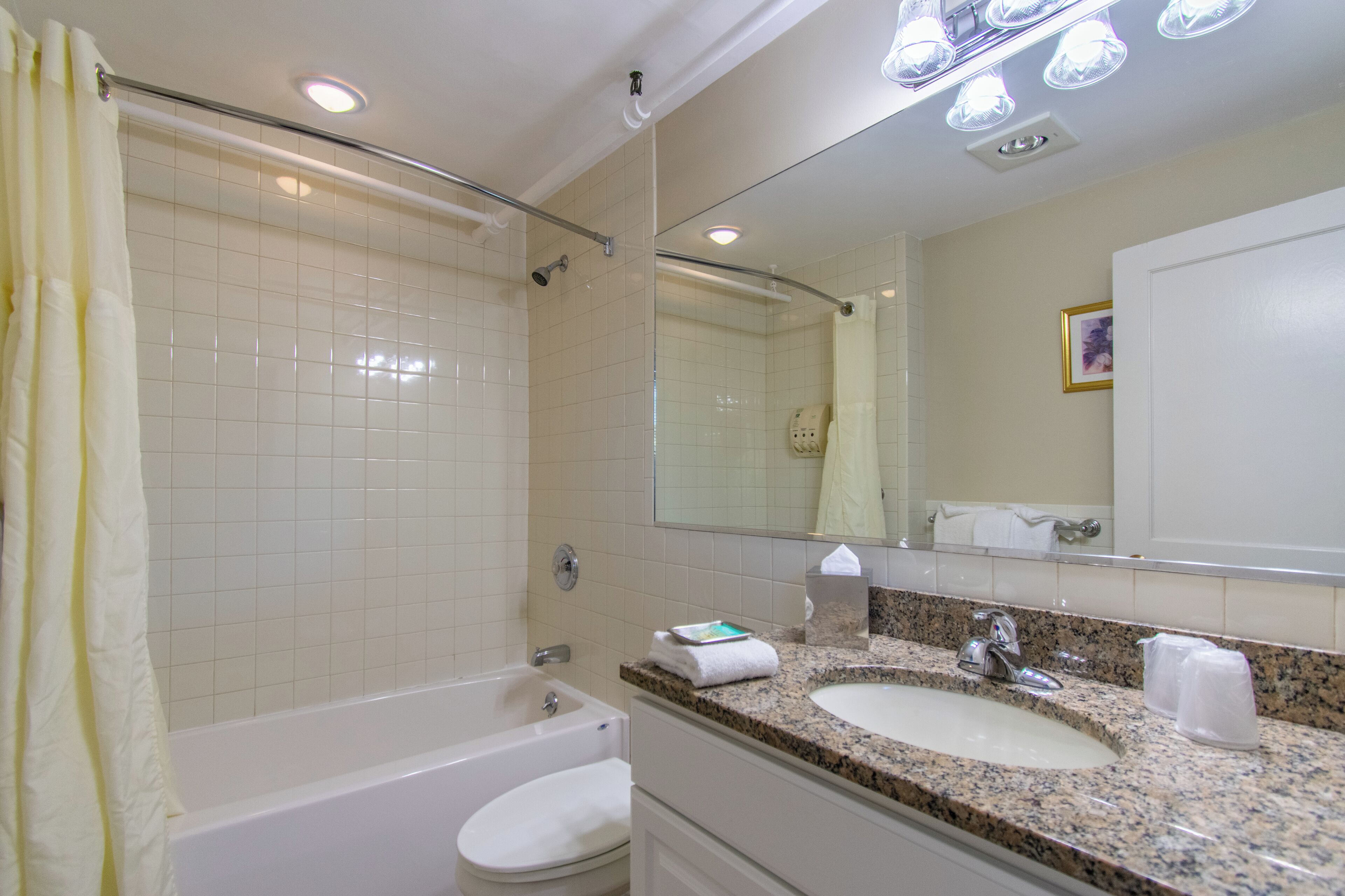 A bathroom with a bathtub, a sink, a mirror, and a shower.
