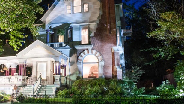 A large, two-story house with a front porch, a staircase, and a brick facade. - Market Street Inn (Taylorville)