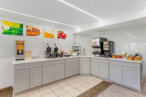 A modern kitchen with a waffle maker, coffee machine, and a sign for fresh coffee. - Quality inn Lancaster (Lancaster)