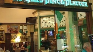 Un restaurante llamado "McGill's Pint & Platter" con mesas en el interior y un cartel de menú a la vista.