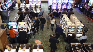 Un casino con numerosas máquinas de juego y una zona de apuestas de alto riesgo.