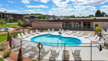 Relax by the oval-shaped pool surrounded by lounge chairs and lush greenery.