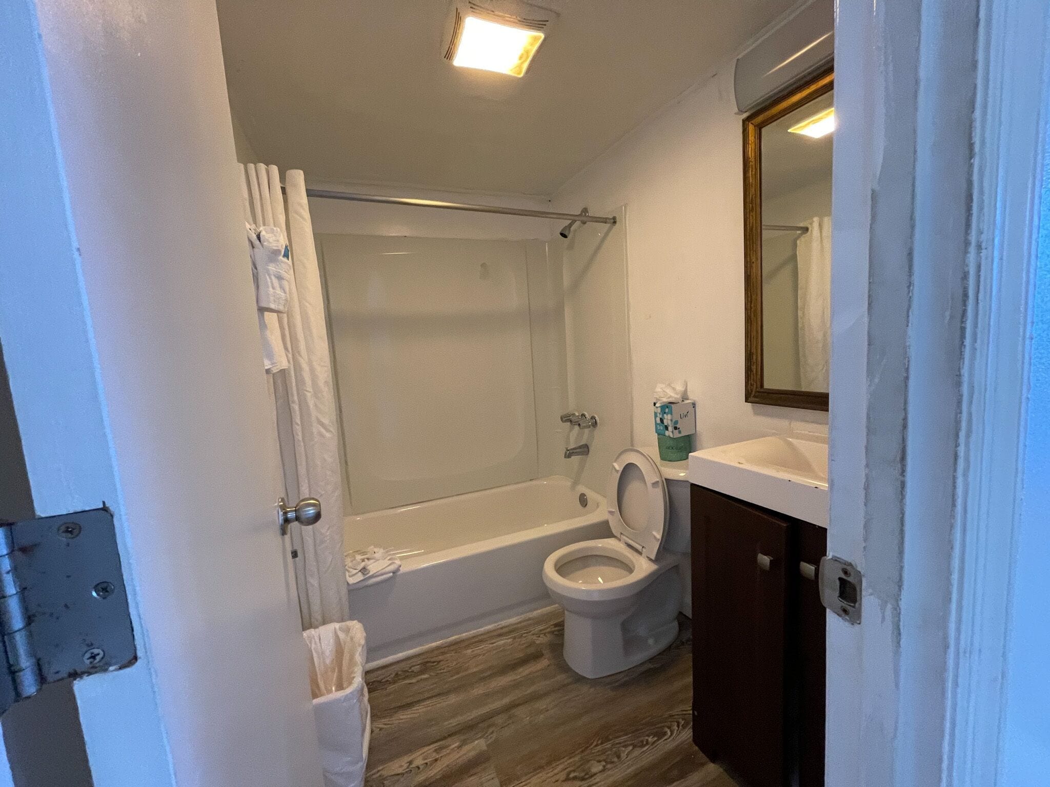Een badkamer met douche, toilet en wastafel.
