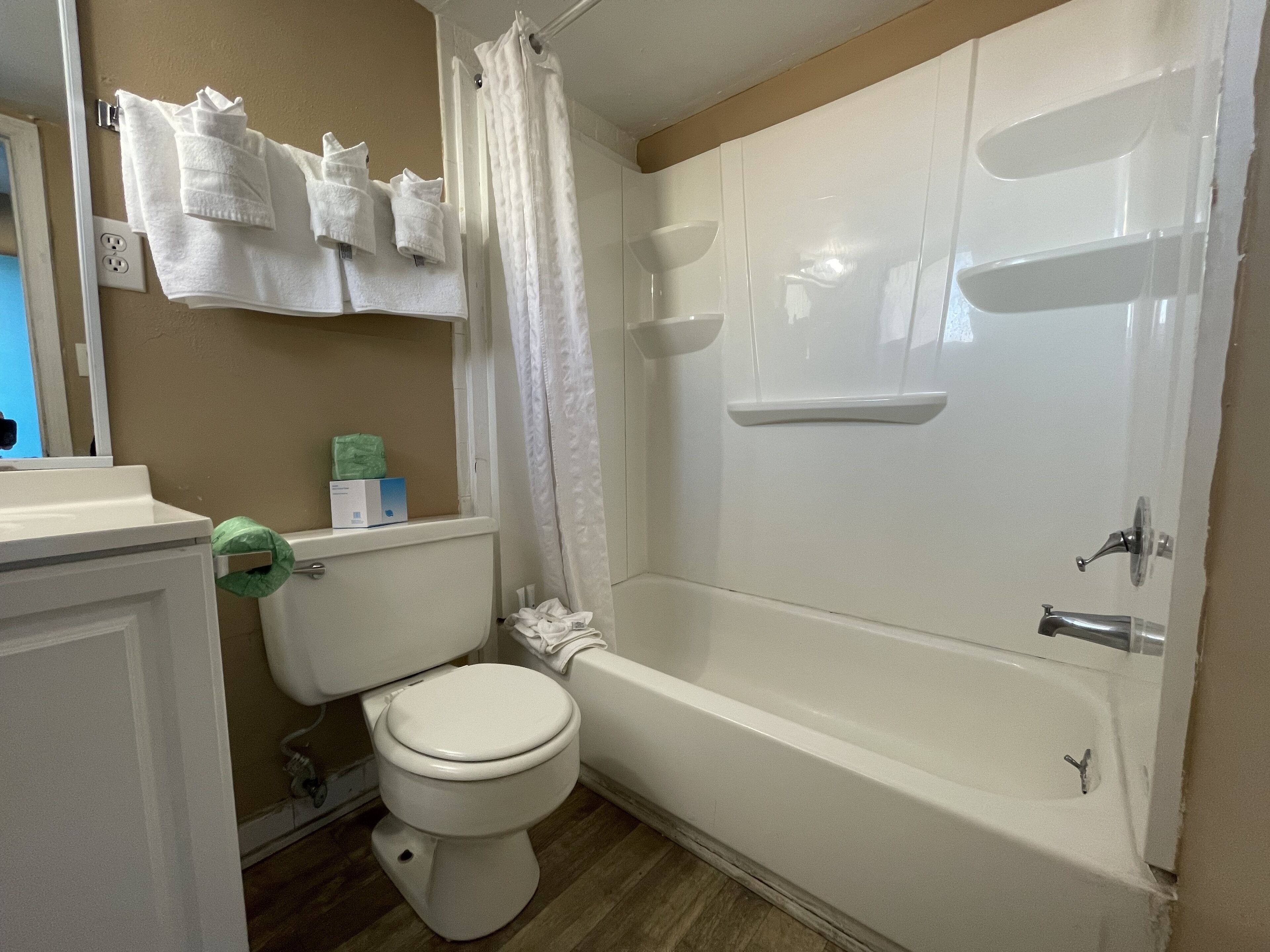 Un baño con inodoro, bañera y cortina de ducha.