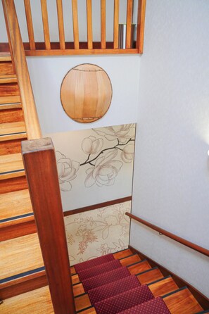 Staircase leads to an upper level with a decorative panel featuring a floral design.