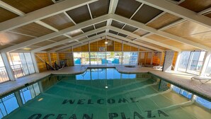 Une piscine intérieure avec une inscription au sol indiquant « Bienvenue à Ocean Plaza ».