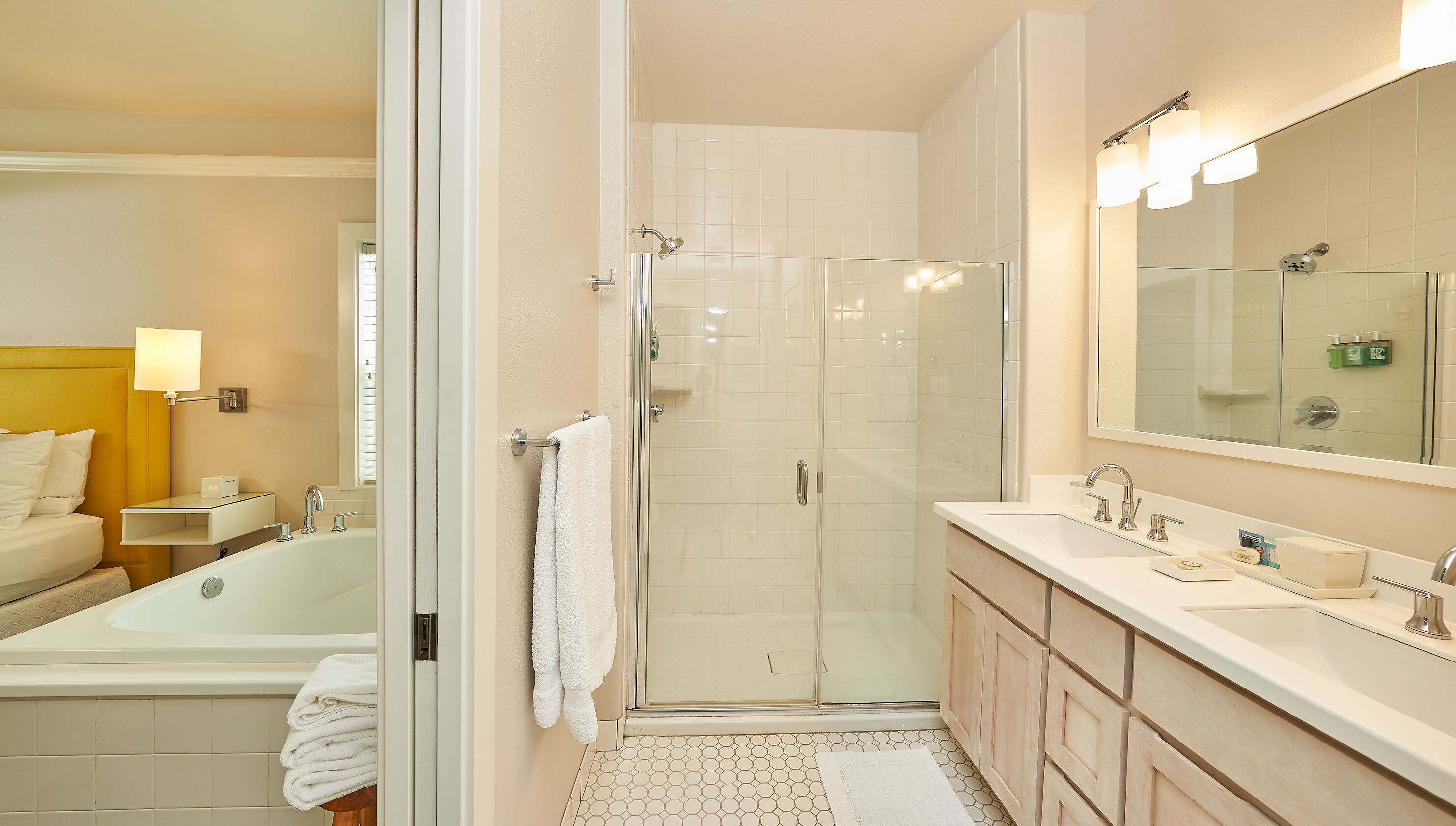 A modern bathroom with a glass-enclosed shower, a large mirror, and a separate bathtub.