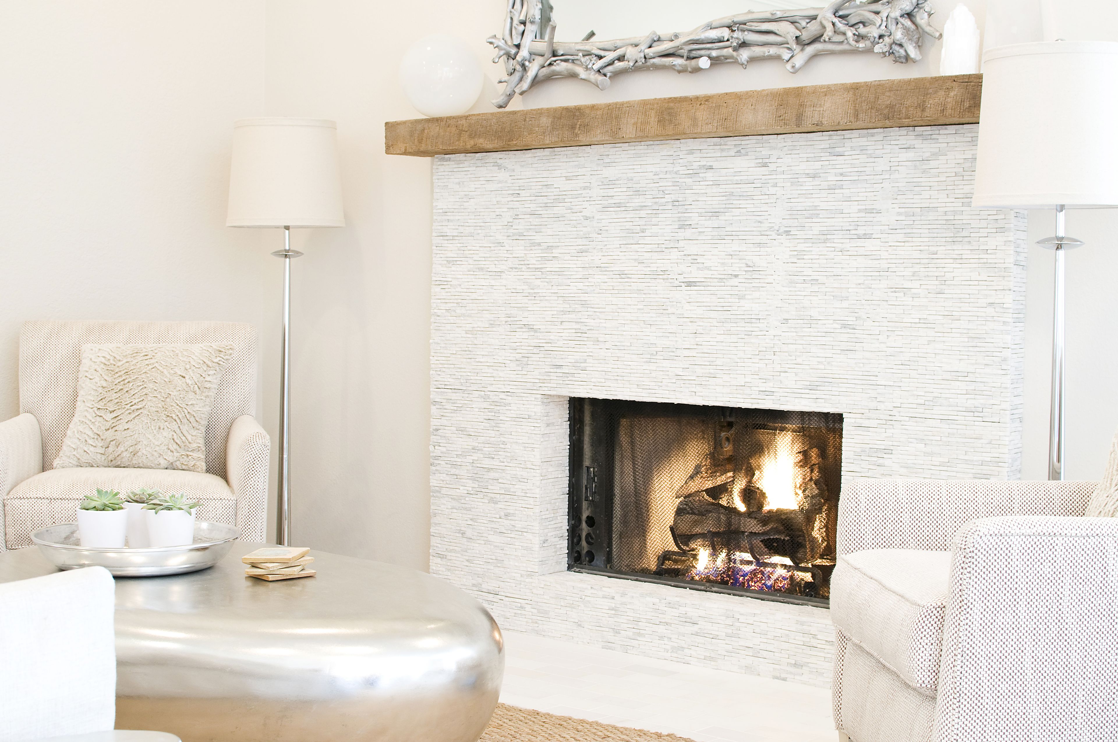 A living room with a fireplace, a sofa, a coffee table, and a floor lamp.